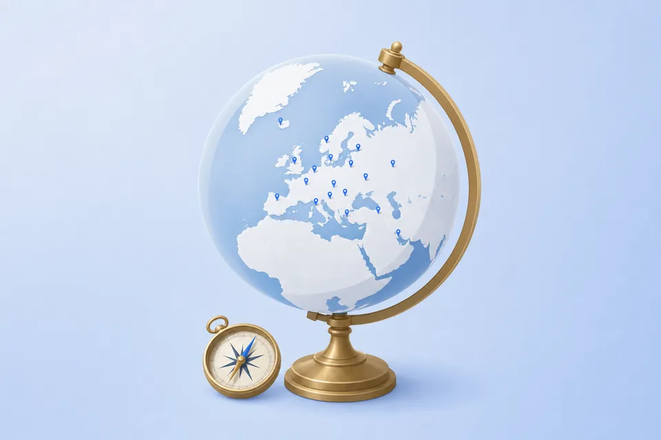 A desk globe turned to Europe with small blue map pins in its capitals, and a brass compass